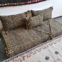 Left view of handwoven Moroccan floor couch in black and mustard – perfect for edgy, warm-toned home styling