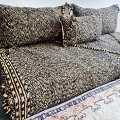 Left view of handwoven Moroccan floor couch in black and mustard – perfect for edgy, warm-toned home styling