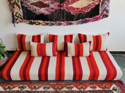 Main image of handmade Moroccan wool floor sofa in cream with red and orange stripes – artisan low seating with cushion cover set for cozy boho living rooms in the USA, UK, and Australia