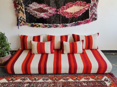 Main image of handmade Moroccan wool floor sofa in cream with red and orange stripes – artisan low seating with cushion cover set for cozy boho living rooms in the USA, UK, and Australia