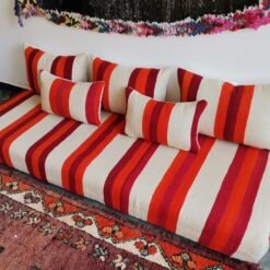 Top view of artisan Moroccan wool sofa in cream with red and orange stripes – handmade floor seating for bohemian and minimalist spaces