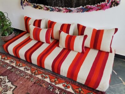 Top view of artisan Moroccan wool sofa in cream with red and orange stripes – handmade floor seating for bohemian and minimalist spaces