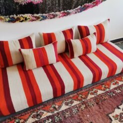 Left side of handmade Moroccan wool couch in cream with red and orange stripes – low floor seating for cozy boho-chic home decor
