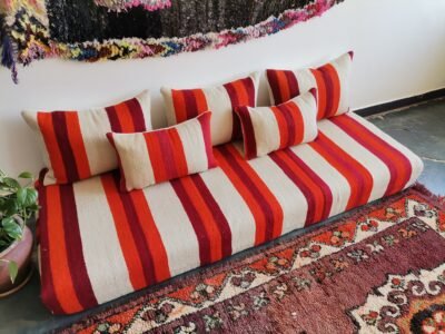 Left side of handmade Moroccan wool couch in cream with red and orange stripes – low floor seating for cozy boho-chic home decor