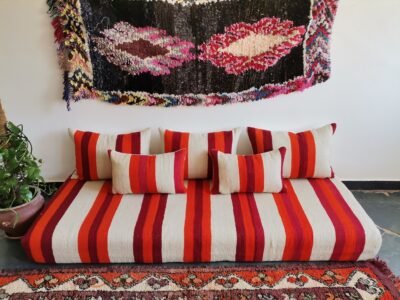 Top view of artisan Moroccan wool sofa in cream with red and orange stripes – handmade floor seating for bohemian and minimalist spaces