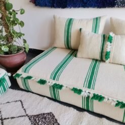 Right view of handmade Moroccan floor sofa with green lines and decorative pom-poms – artisan wool couch for fun bohemian homes
