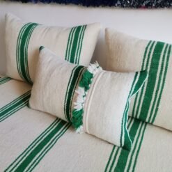 Moroccan sofa in cream with green stripes and pom-pom detail – artisan wool pillows for joyful boho decor