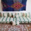 Moroccan wool floor sofa in cream with green stripes and pom-pom trim – handmade low seating for playful boho interiors