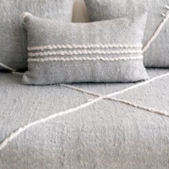 Close-up of handmade light gray cushion covers on Moroccan sofa – minimalist and modern floor couch pillows