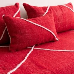 Detail of plain red cushions on Moroccan couch – soft handcrafted pillows for boho, rustic, or eclectic rooms