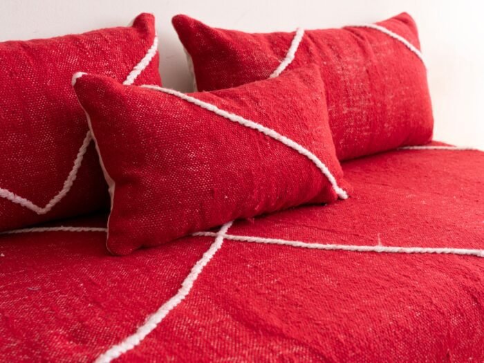Detail of plain red cushions on Moroccan couch – soft handcrafted pillows for boho, rustic, or eclectic rooms