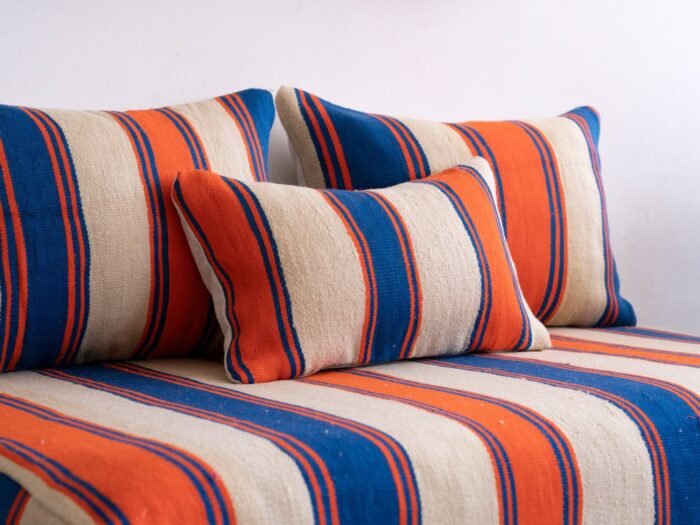 Close-up of cushions from Moroccan wool floor couch in Cream with Blue and Orange Stripes – artisan pillow covers for cozy and stylish home decor