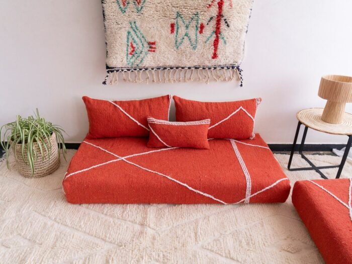 Handwoven orange Moroccan floor couch with minimalist cushions – ideal for boho-chic or eclectic living room decor