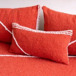 Detail of plain orange pillows on floor sofa – artisan handmade cushions for bold and boho living spaces