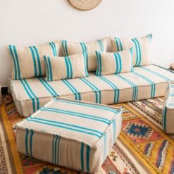 Left side image of Moroccan floor seating with turquoise striped pattern on cream – handmade wool low sofa
