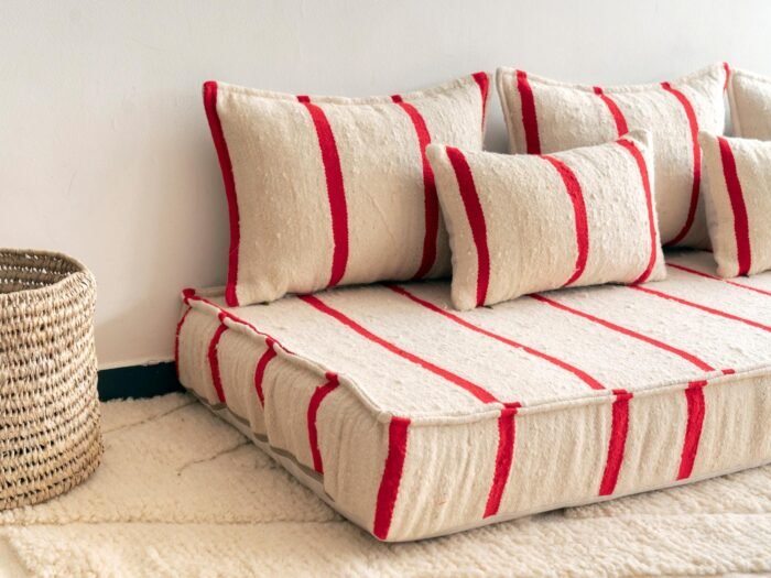 Left side of Moroccan wool floor sofa in cream with red stripes – handmade seating for stylish boho and rustic home decor
