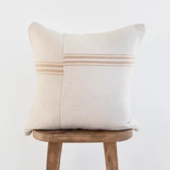 Front view of handmade Moroccan pillow cover in cream white cotton with elegant tan stripes – artisan woven cushion for boho, rustic, or neutral interiors
