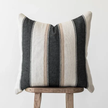 Moroccan throw pillow with bold cream, tan, and black stripes – handwoven cotton cushion styled for modern neutral or bohemian home interiors