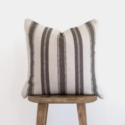 Front view of handwoven Moroccan pillow in white with horizontal warm grey stripes – minimalist and artisan cotton cushion for neutral interiors