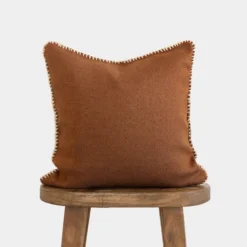 Front view of Moroccan pillow in spice color with cream stitching around the edges – handmade cotton cushion for boho and earthy interiors