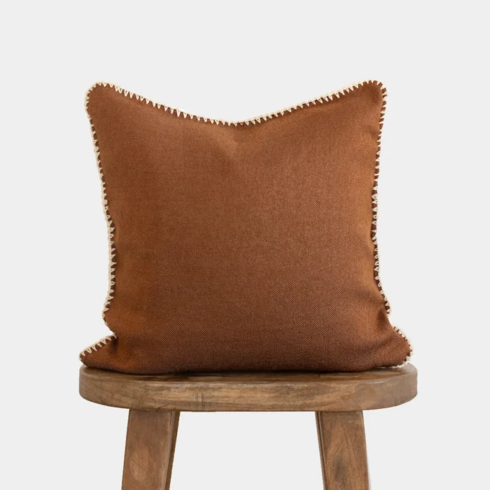 Front view of Moroccan pillow in spice color with cream stitching around the edges – handmade cotton cushion for boho and earthy interiors