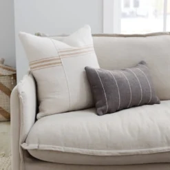 Cream and tan Moroccan pillow cover displayed on a rustic wooden chair in a minimalist room – handcrafted cotton cushion for boho, coastal, or Japandi interiors