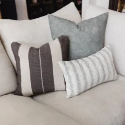 Dark grey pillows with off white stripes styled in contemporary living space – handwoven Moroccan cotton throw pillows for cozy and stylish interiors