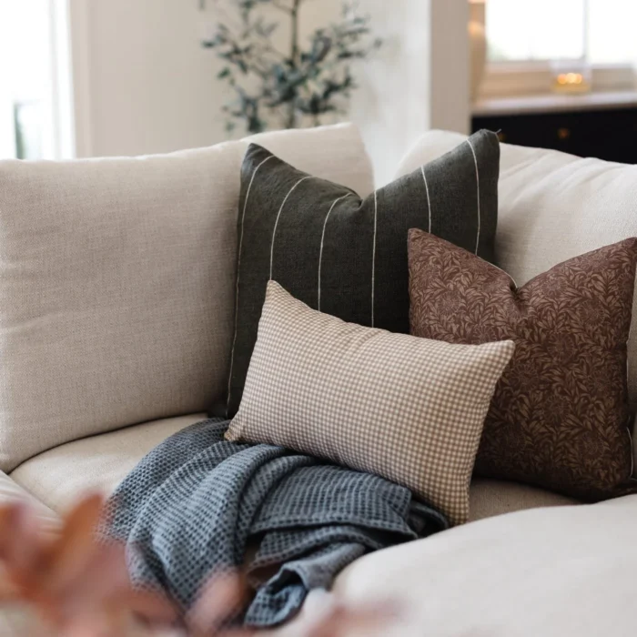Handwoven Moroccan pillow in moss green with off-white stripes styled in boho interior – natural earthy cotton cushion for relaxed living spaces