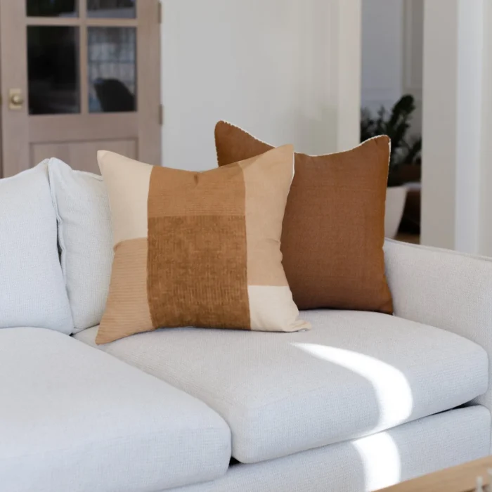 Spice-toned Moroccan pillows with cream edge stitching styled in a cozy, bohemian room – handmade cotton cushions for natural interiors