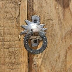 Traditional Moroccan silver door knocker on handcrafted wooden surface