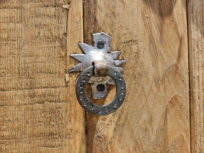 Traditional Moroccan silver door knocker on handcrafted wooden surface