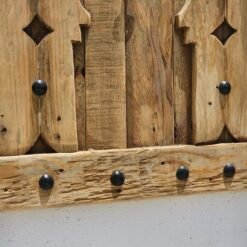 Close-up of bottom detail of Moroccan wooden panel showing natural wood grain and studs