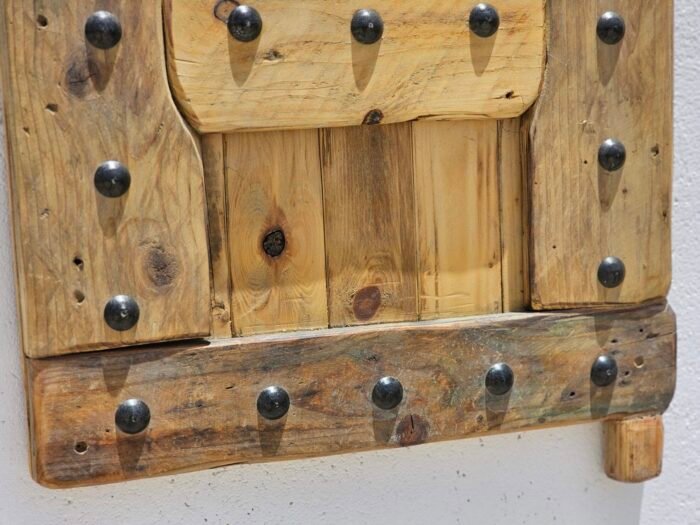 Bottom panel view of the rustic Moroccan shutter with visible wood grain and iron rivets