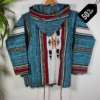 Turquoise and black patterned handmade Moroccan fleece hoodie, unisex Berber-inspired boho jacket with cozy hood and traditional wooden toggle buttons, crafted from premium natural wool and fleece – warm artisan outerwear perfect for festivals, travel, casual wear, and layering, popular in USA, UK, and European bohemian fashion markets.