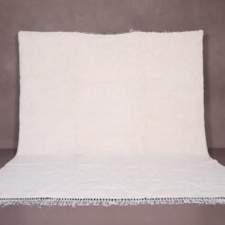 Authentic handmade Moroccan white Beni Ourain rug crafted from 100% natural wool by skilled Berber women artisans. This minimalist solid white wool carpet features a soft texture and timeless elegance, perfect for modern, Scandinavian, or bohemian home interiors. Ideal for living rooms, bedrooms, or wall decor.