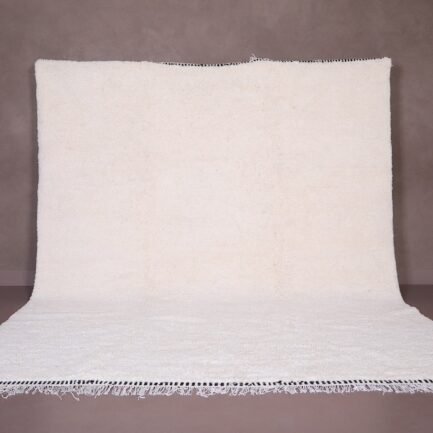 Authentic handmade Moroccan white Beni Ourain rug crafted from 100% natural wool by skilled Berber women artisans. This minimalist solid white wool carpet features a soft texture and timeless elegance, perfect for modern, Scandinavian, or bohemian home interiors. Ideal for living rooms, bedrooms, or wall decor.