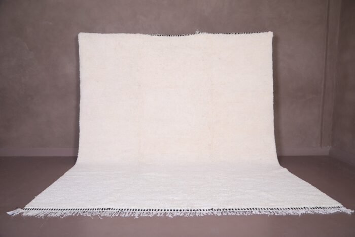 Authentic handmade Moroccan white Beni Ourain rug crafted from 100% natural wool by skilled Berber women artisans. This minimalist solid white wool carpet features a soft texture and timeless elegance, perfect for modern, Scandinavian, or bohemian home interiors. Ideal for living rooms, bedrooms, or wall decor.