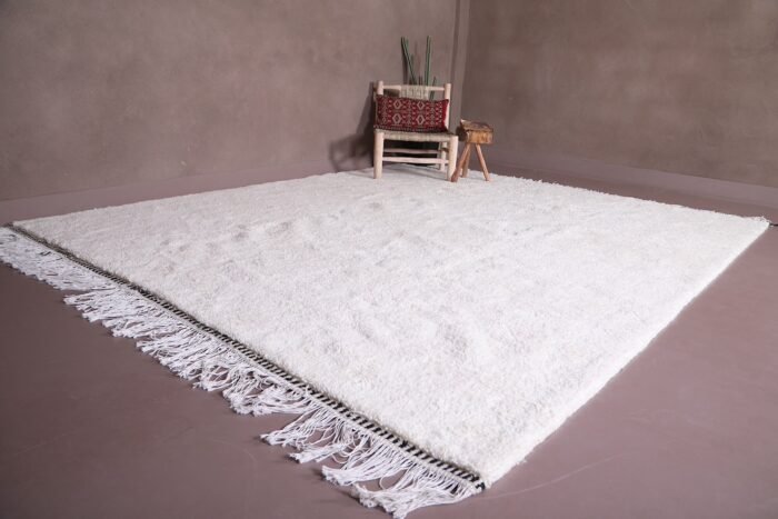 authentic white Moroccan Beni Ourain rug, highlighting the craftsmanship of each knot and the solid white wool weave. This elevated angle gives a closer look at the detail, making it a perfect piece for home décor enthusiasts and interior designers.