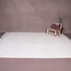 handcrafted Moroccan white Beni Ourain wool rug, showcasing the thickness and texture of its hand-knotted design. This premium wool rug adds warmth and sophistication to any space and fits beautifully in minimalist, boho, or rustic-themed rooms.