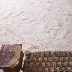 handmade white Moroccan Beni Ourain wool rug, displaying its minimalist design and geometric precision. Perfect as a floor covering or artistic wall hanging, this view emphasizes the rug’s cultural and decorative value