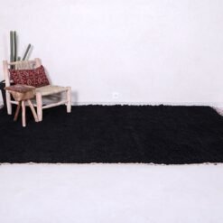 traditional black Moroccan Beni Ourain rug, highlighting the precision of Berber craftsmanship and the smooth finish of high-quality natural wool. A luxurious accent for bedrooms, lofts, or cozy reading nooks