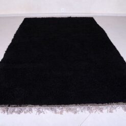 hand-knotted Moroccan black Beni Ourain rug showing the plush wool texture and thick pile. Woven in the Atlas Mountains, this rug adds depth and softness to any room while standing out as a timeless statement piece