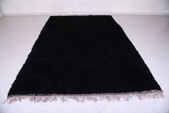 hand-knotted Moroccan black Beni Ourain rug showing the plush wool texture and thick pile. Woven in the Atlas Mountains, this rug adds depth and softness to any room while standing out as a timeless statement piece