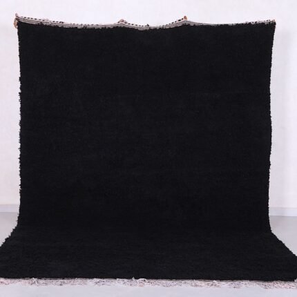 Authentic handmade Moroccan black Beni Ourain rug crafted from 100% natural wool by skilled Berber women artisans. This luxurious black wool rug brings bold elegance, warmth, and cultural charm to modern, bohemian, or minimalist interiors. Perfect for living rooms, bedrooms, or as an eye-catching wall tapestry.