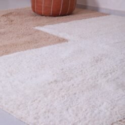 fringe on Moroccan ivory and tan rug, showcasing the hand-knotted finish and soft wool fiber quality.