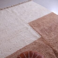 contemporary Moroccan wool rug in tan and ivory tones, highlighting its clean pattern and thick weave.