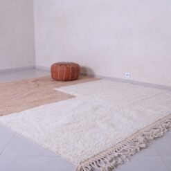Moroccan ivory and tan rug showing minimalist pattern and soft wool texture, handwoven in the Atlas Mountains.