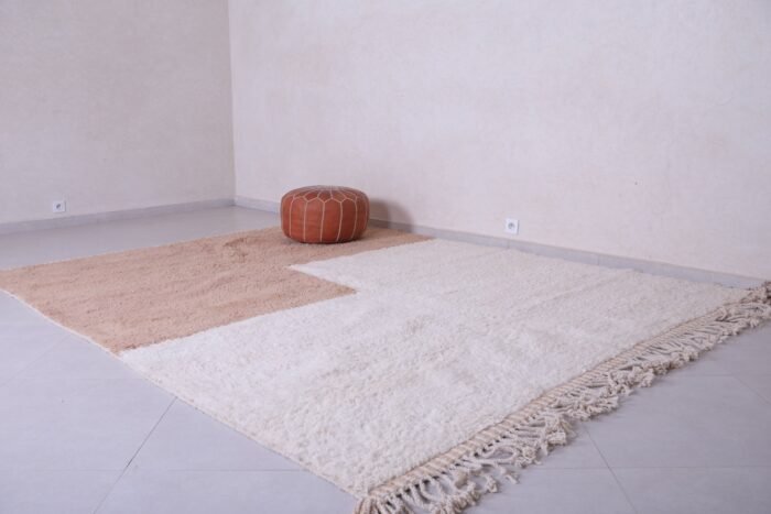 Moroccan ivory and tan rug showing minimalist pattern and soft wool texture, handwoven in the Atlas Mountains.