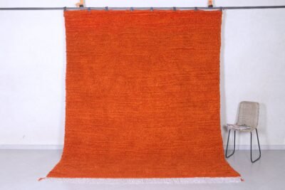 Authentic handmade Moroccan orange Beni Ourain rug crafted with 100% natural wool by Berber artisans, featuring vibrant rustic orange color and traditional geometric Berber tribal patterns, perfect for living rooms and cozy interiors.