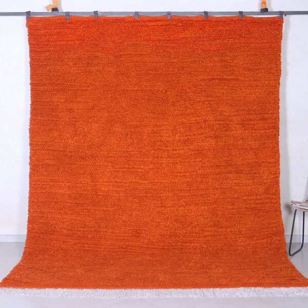 Authentic handmade Moroccan orange Beni Ourain rug crafted with 100% natural wool by Berber artisans, featuring vibrant rustic orange color and traditional geometric Berber tribal patterns, perfect for living rooms and cozy interiors.